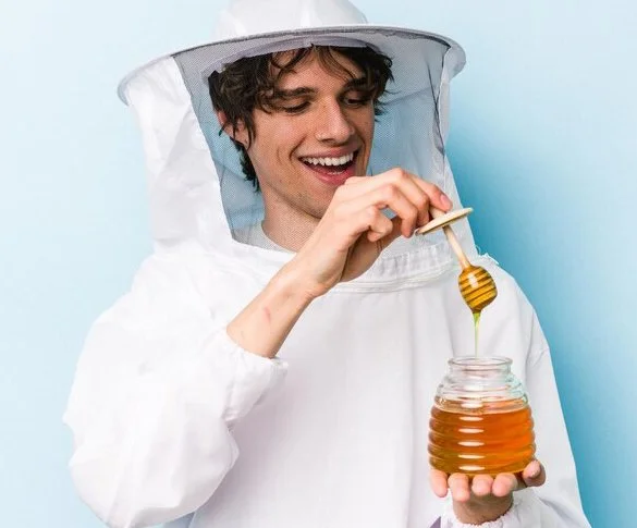 A man is showing honey that has ten benefits, mentioned in the blog.